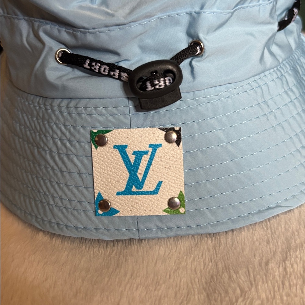Beautiful light blue bucket hat with a Louis Vuitton emblem on the hat COA